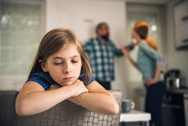Traumatized daughter listening parents arguing at home
